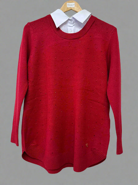 Red sweater on a hanger with a white shirt underneath against a plain background