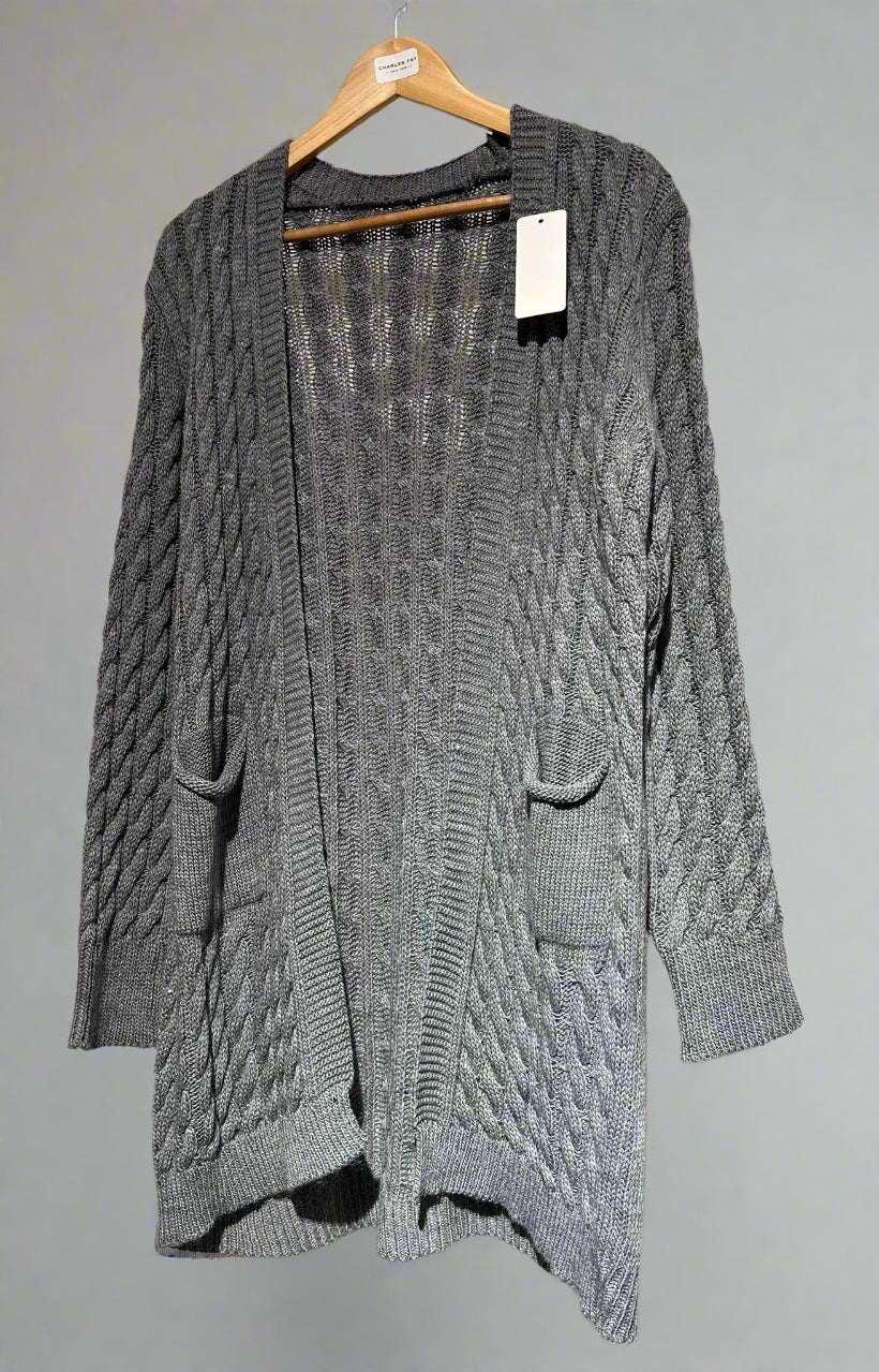 Gray cable knit cardigan on a hanger against a neutral background