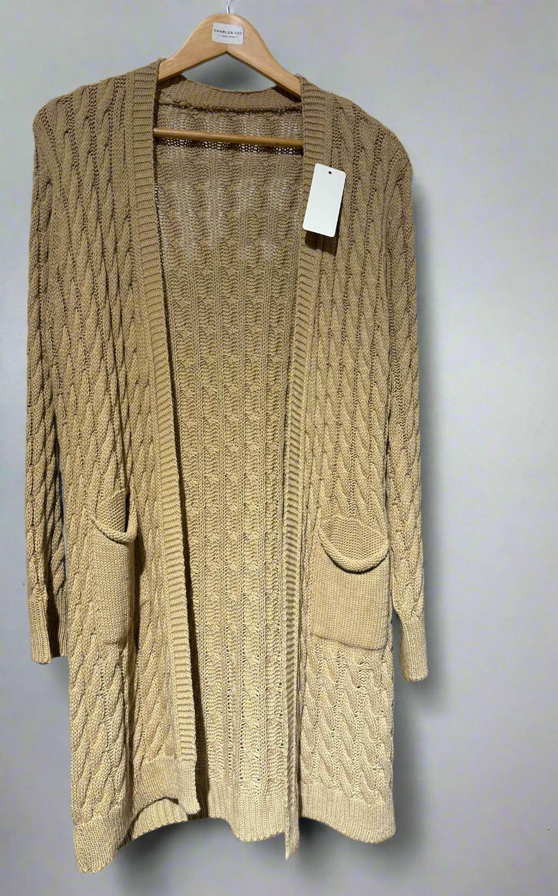 Beige cable knit cardigan on a hanger against a white background